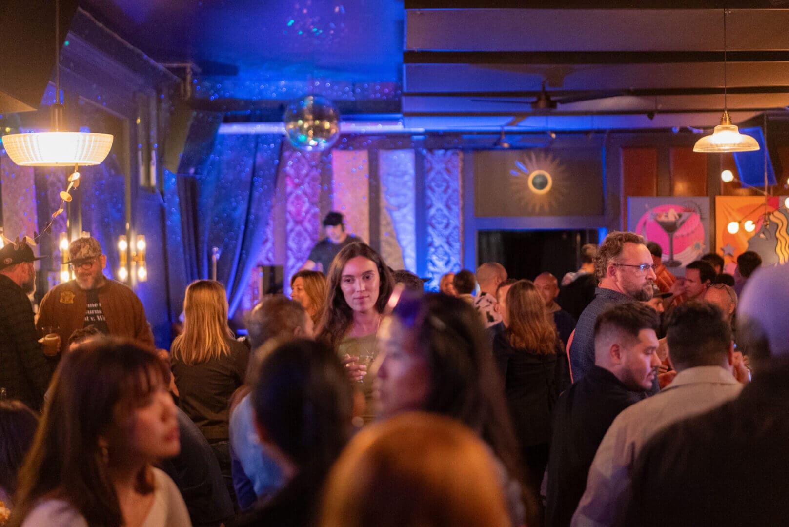 Crowded bar with people socializing and mingling.